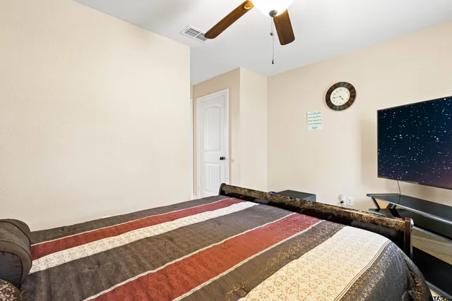 a bedroom with a bed and a lamp with the dresser