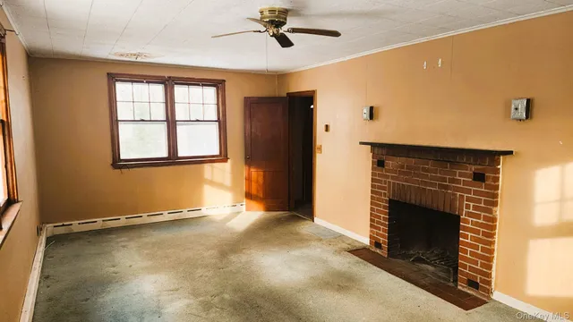 a view of an empty room with a fireplace and a window