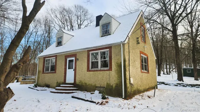 a front view of a house with a tree