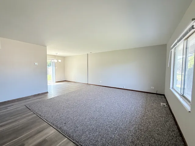 a view of an empty room with window and cabinet