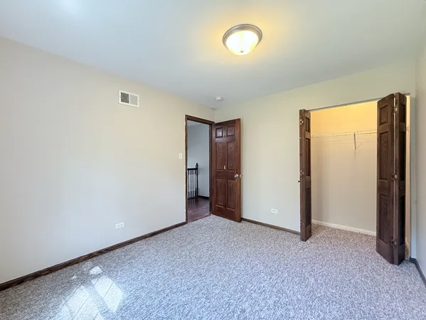 an empty room with a window and a ceiling fan