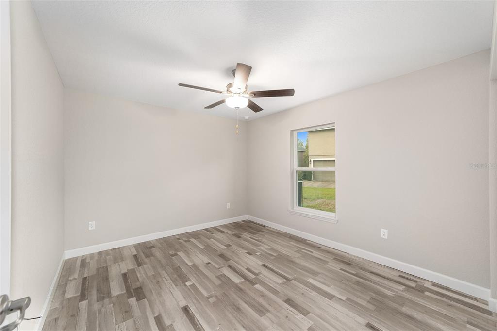 11339 Southwest 65th Ave Road Ocala, FL 34476 - Photo 38 of 42 an empty room with a window and a fan