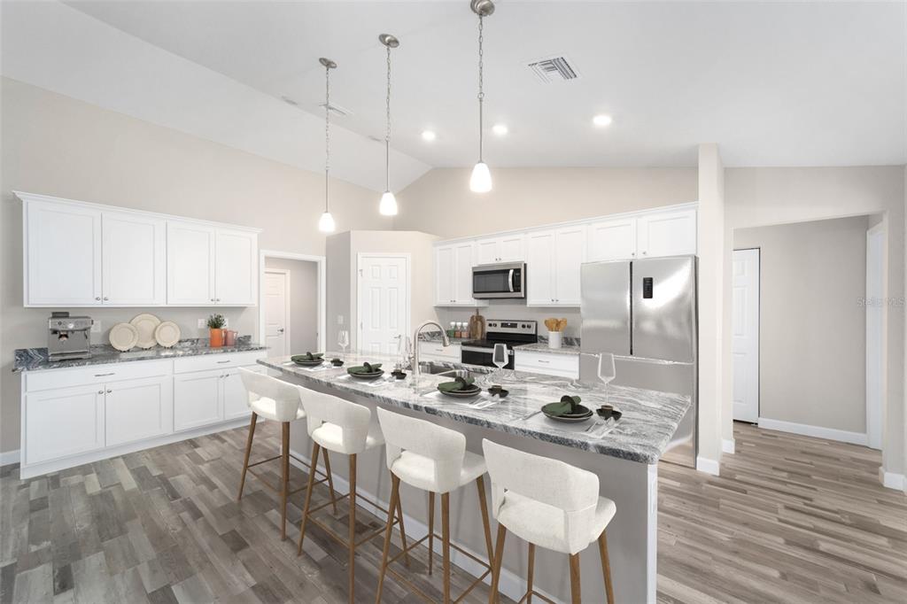 11339 Southwest 65th Ave Road Ocala, FL 34476 - Photo 10 of 42 a kitchen with stainless steel appliances kitchen island granite countertop a sink a stove a refrigerator cabinets and chairs