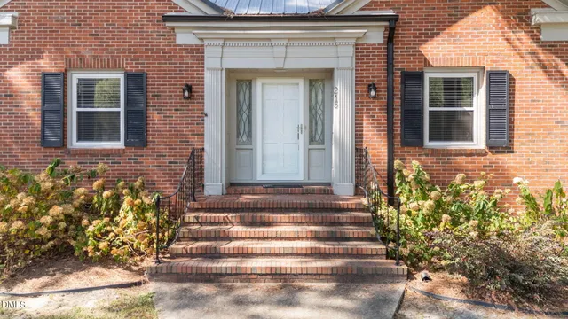 a kitchen with stainless steel appliances granite countertop a stove top oven a sink dishwasher and a refrigerator with wooden floor