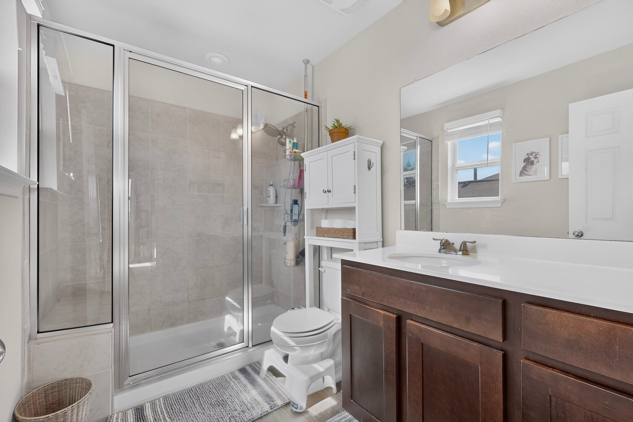 132 Wapiti Road Buda, TX 78610 - Photo 11 of 31 A well-lit bathroom features a glass-enclosed shower alongside a vanity with ample counter space.