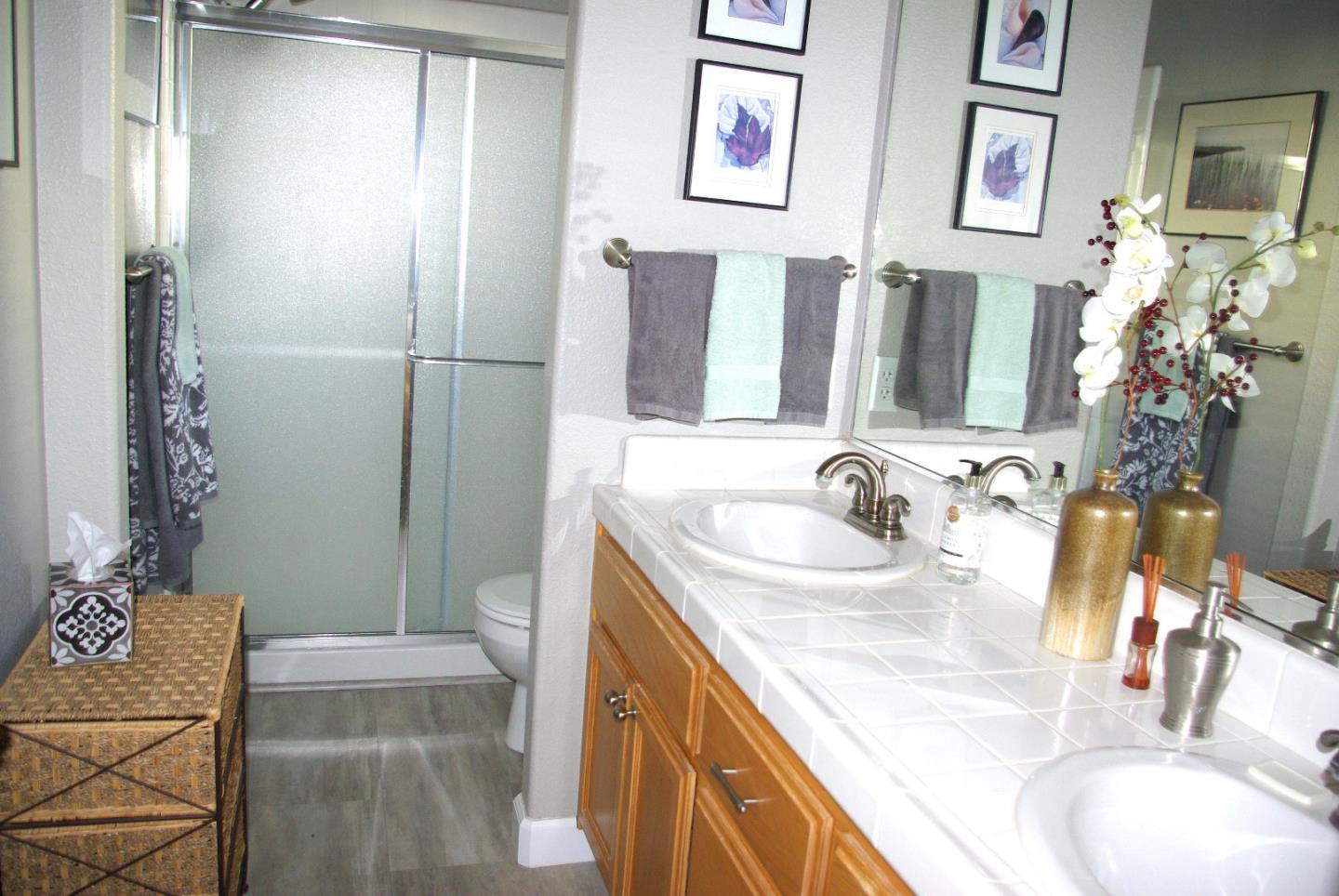 1530 Rosette Way Gilroy, CA 95020 - Photo 10 of 12 a bathroom with a granite countertop sink a mirror and a shower