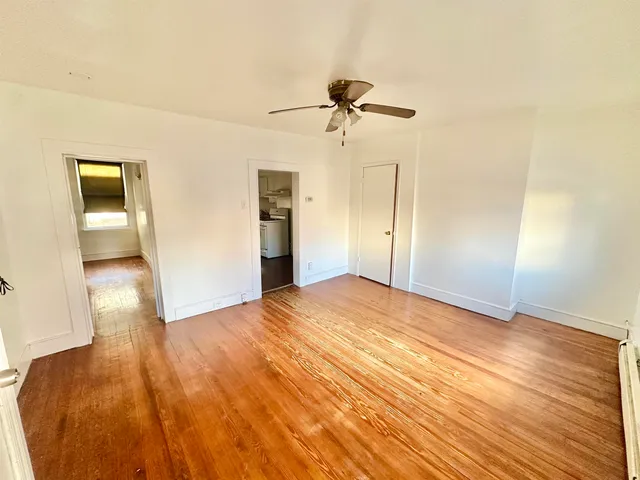 a view of empty room with wooden floor