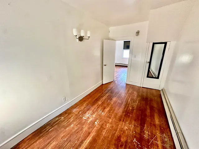 a view of a hallway with wooden floor and stairs