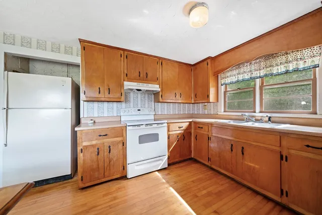 a kitchen with granite countertop a sink stainless steel appliances and cabinets