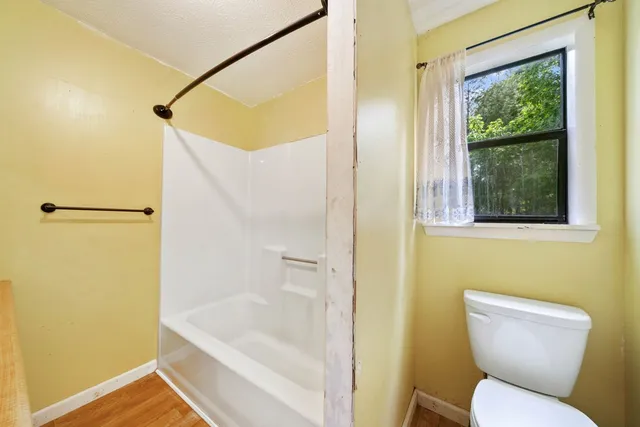 a bathroom with a toilet and a shower