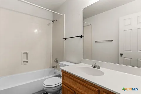 a bathroom with a granite countertop sink toilet tub and shower