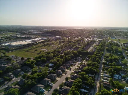 an aerial view of residential house with ocean and trees