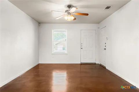 wooden floor in an empty room with a window