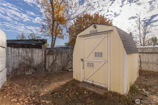 a view of a house with a yard and wooden fence