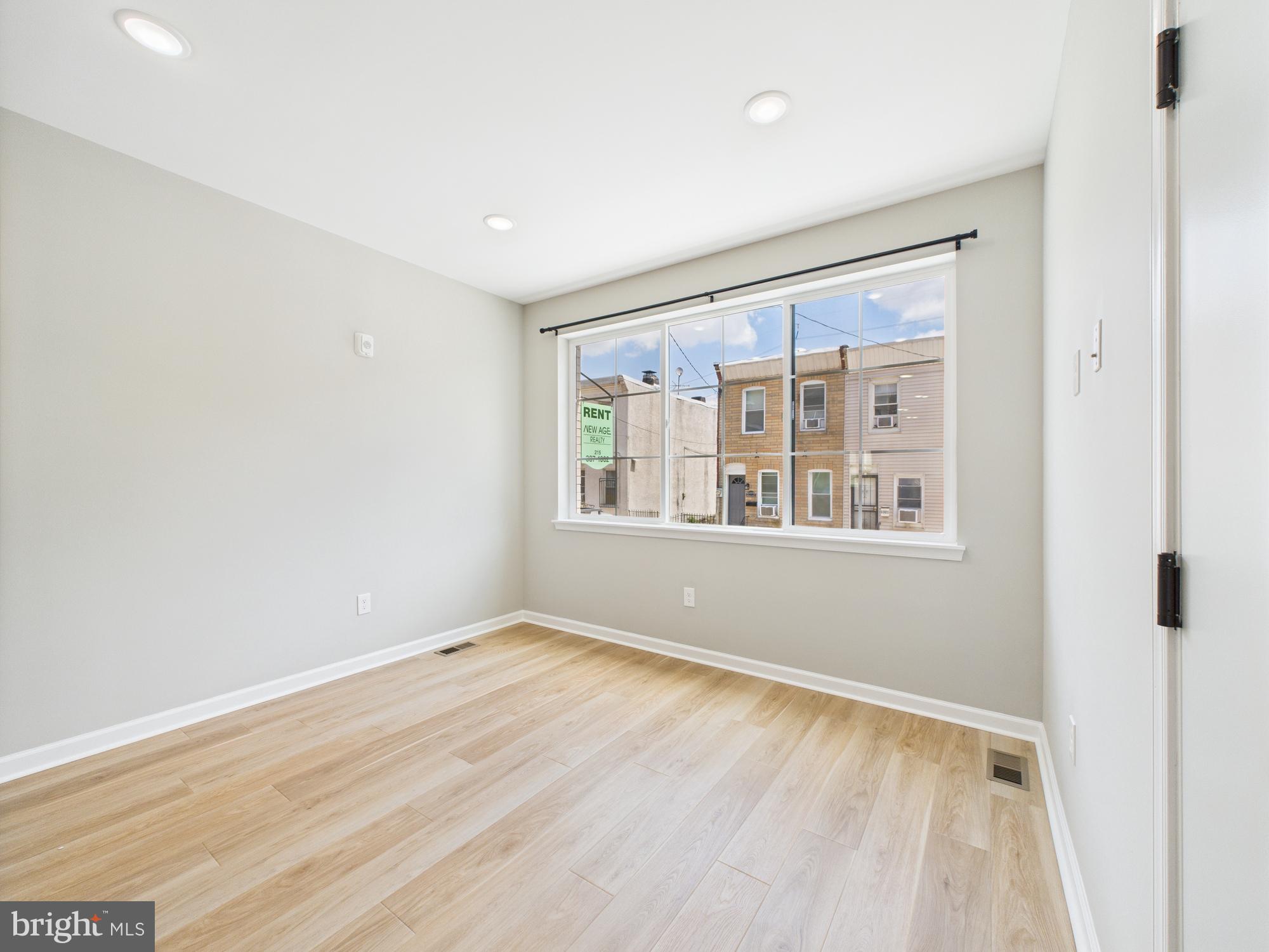 1320 Grove Street, Unit 1 Philadelphia, PA 19146 - Photo 14 of 15 a view of an empty room with wooden floor and a window