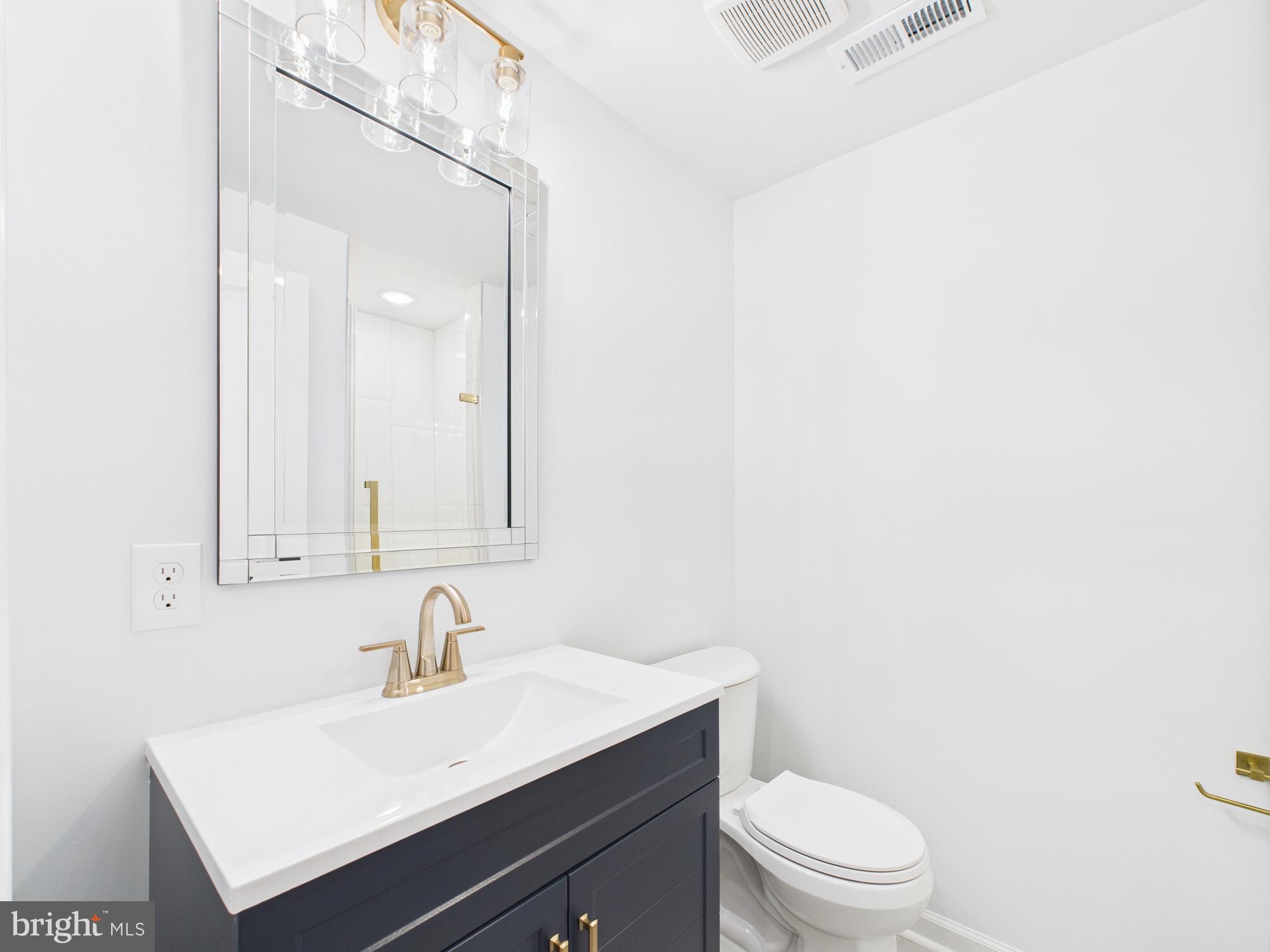 1320 Grove Street, Unit 1 Philadelphia, PA 19146 - Photo 5 of 15 a bathroom with a sink a toilet and a mirror