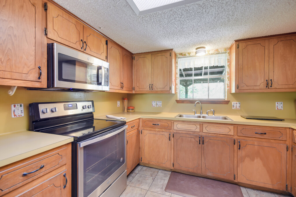 301 Navajo Trail Georgetown, TX 78633 - Photo 25 of 35 Kitchen with appliances with stainless steel finishes, a sink, a textured ceiling, light countertops, and light tile patterned floors