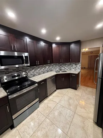 a kitchen with stainless steel appliances granite countertop wooden cabinets and a granite counter tops