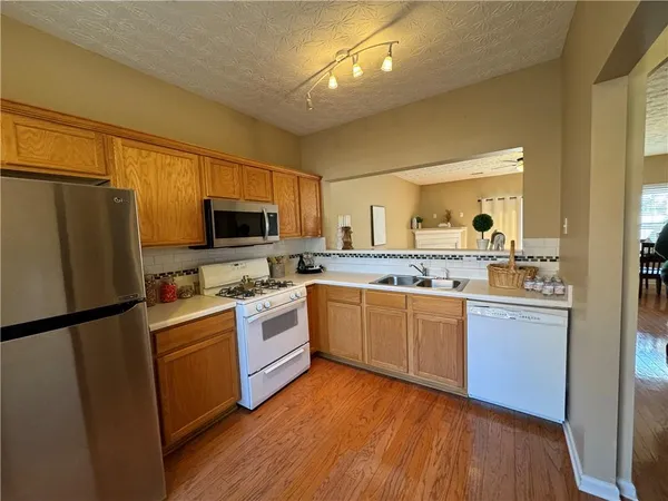a kitchen with granite countertop a refrigerator stove top oven and sink