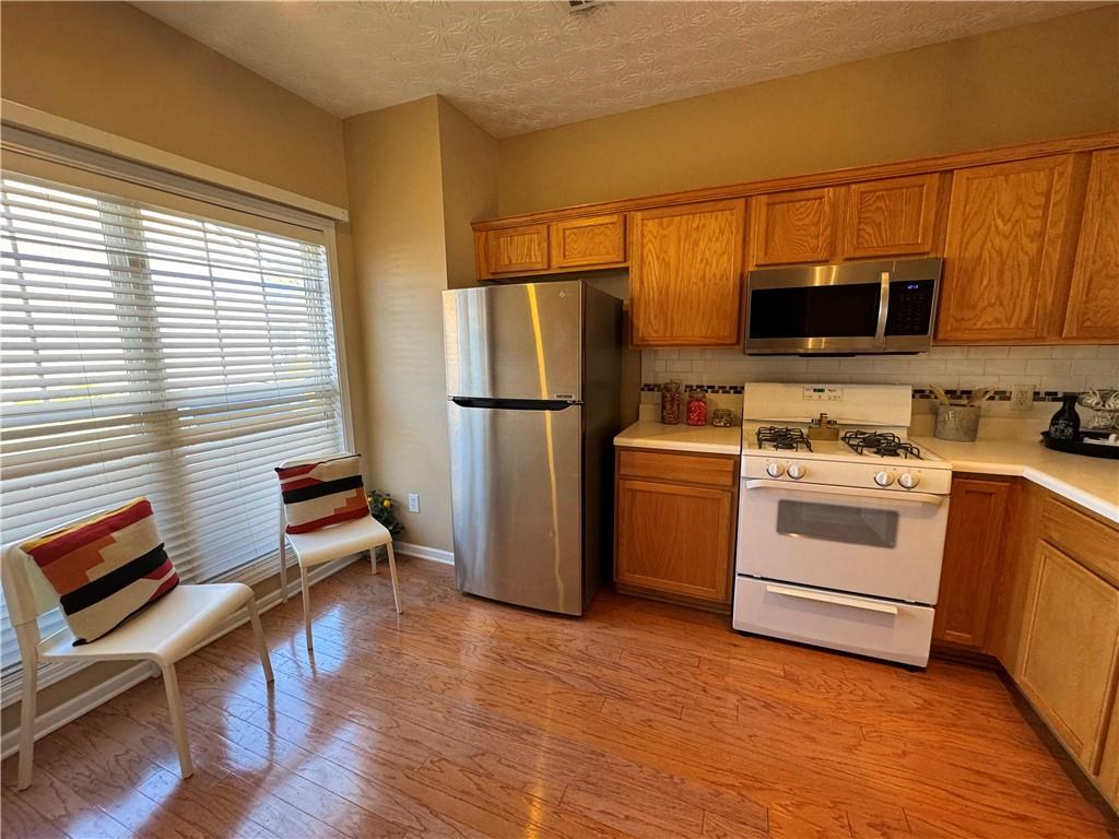 801 Old Peachtree Road Northwest, Unit 8 Lawrenceville, GA 30043 - Photo 23 of 26 a kitchen with a stove a sink and a microwave