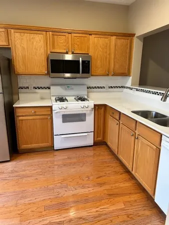 a kitchen with stainless steel appliances granite countertop a stove a sink and a microwave