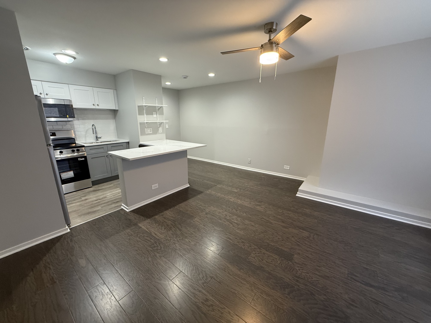 744 West Gordon Terrace, Unit 308 Chicago, IL 60613 - Photo 2 of 15 a large white kitchen with wooden floor