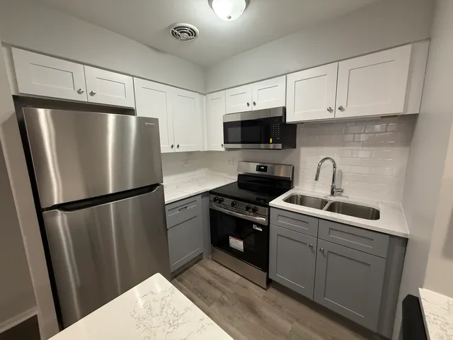 a kitchen with stainless steel appliances a refrigerator sink and microwave