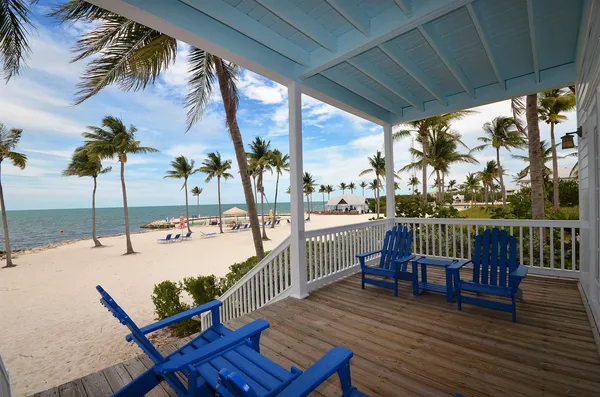 a view of a balcony with chairs and wooden floor