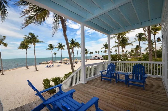 a view of a balcony with chairs and wooden floor