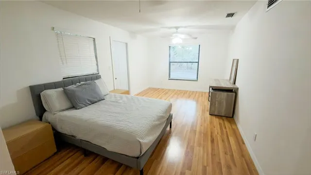 a bedroom with a bed and wooden floor