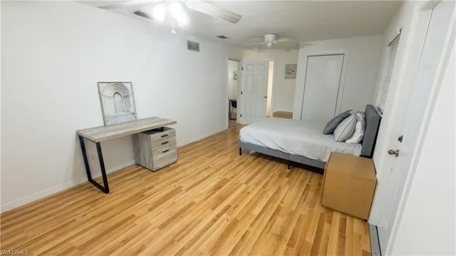 a bedroom with a bed and wooden floor