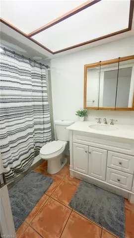 a bathroom with a sink a toilet a mirror and shower