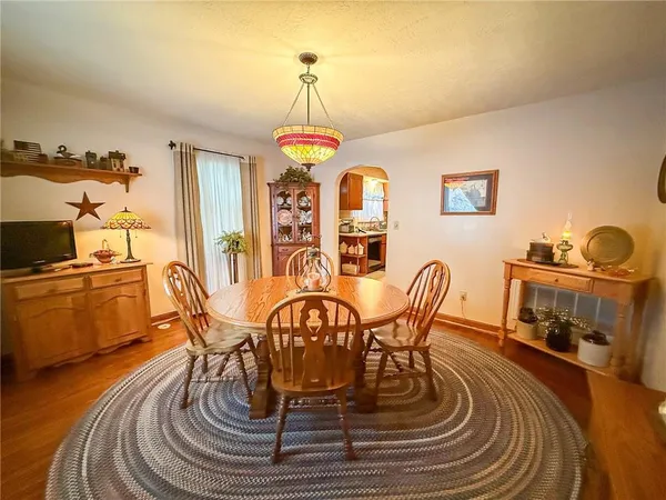 a dining room with furniture a chandelier and wooden floor