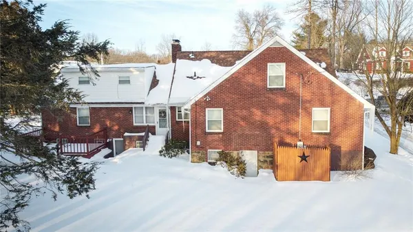 a view of a big house with a big yard and large tree