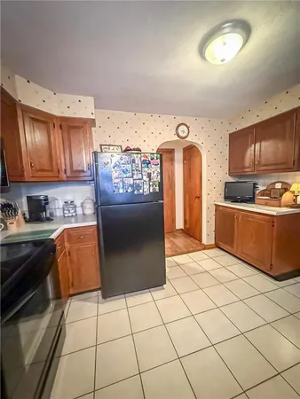 a kitchen with granite countertop a stove a sink and a refrigerator