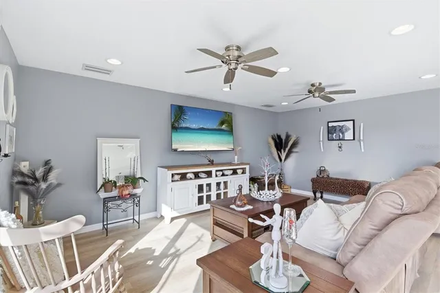 a dining room with furniture a chandelier and wooden floor
