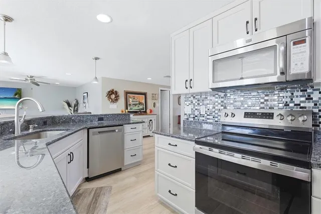 a bathroom with a granite countertop sink toilet tub and shower