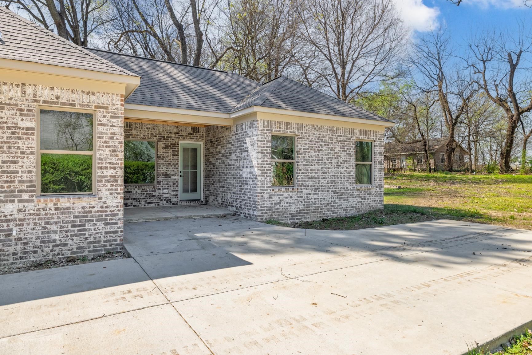 319 North Maple Street Covington, TN 38019 - Photo 31 of 32 View of exterior entry featuring brick siding, a shingled roof, and a patio