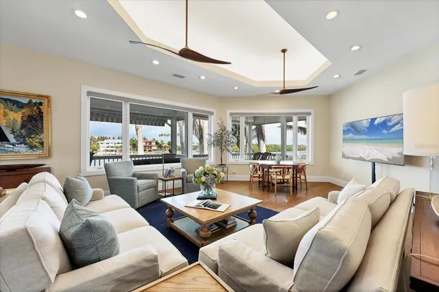 a large white kitchen with lots of furniture a sink appliances and a dining table