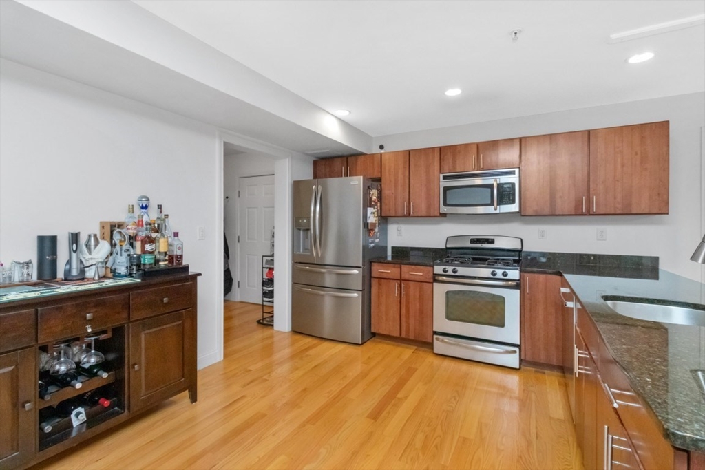 29 Spruce Street, Unit 23 Waltham, MA 02453 - Photo 5 of 26 a kitchen with stainless steel appliances granite countertop a refrigerator stove and sink