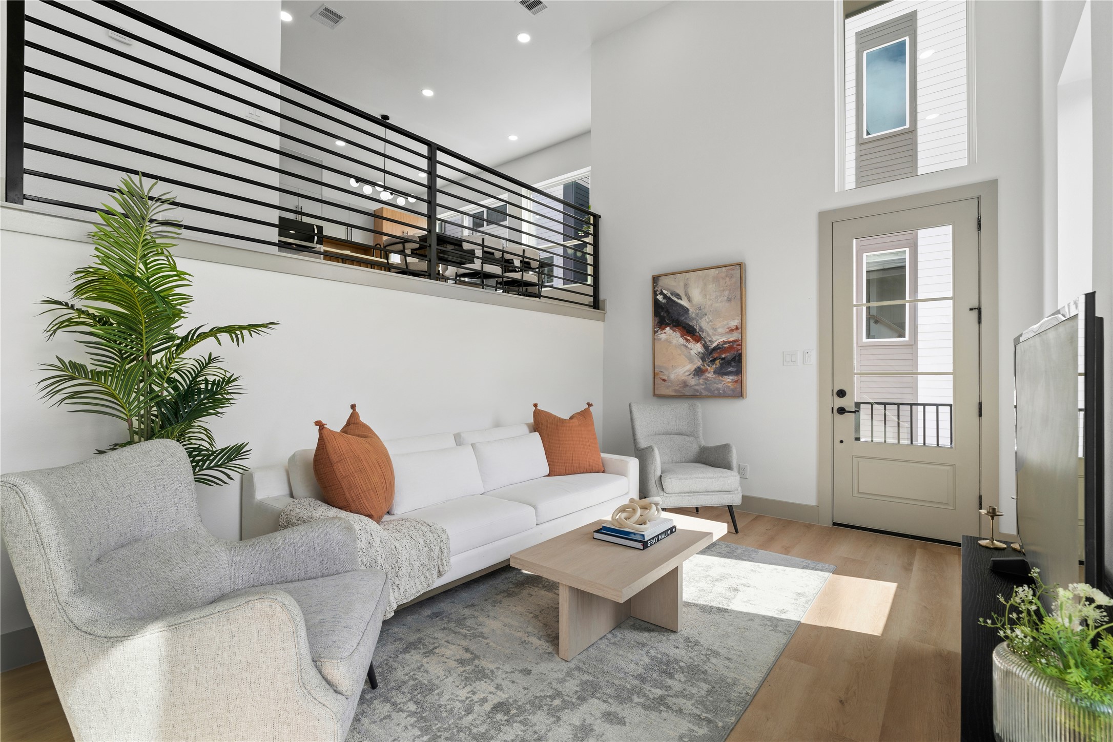 2950 Pitzlin Street Houston, TX 77023 - Photo 4 of 37 Enjoy a bright, modern living space with durable SPC flooring and a stunning visual connection to the dining area above—bringing style and function together across split levels.