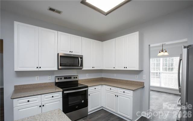 815 Knightsbridge Road Fort Mill, SC 29708 - Photo 10 of 30 a kitchen with granite countertop white cabinets and stainless steel appliances