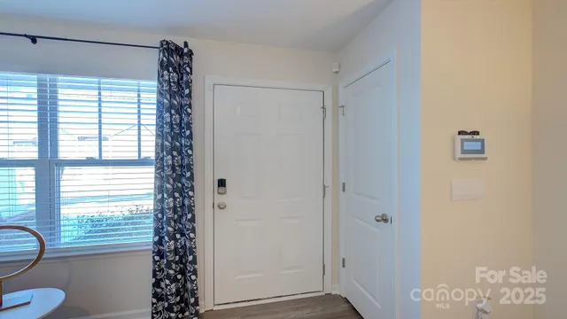 a bathroom with a window a shower and a chair