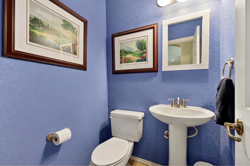 1035 Highland Road Cleburne, TX 76033 - Photo 24 of 36 a bathroom with a toilet a sink and mirror
