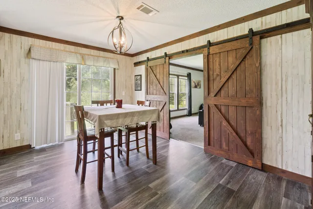 a dining room with wooden floor table and chairs