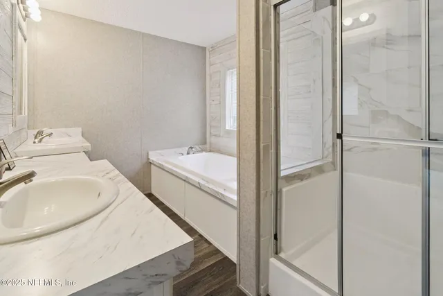 a bathroom with a tub sink and mirror