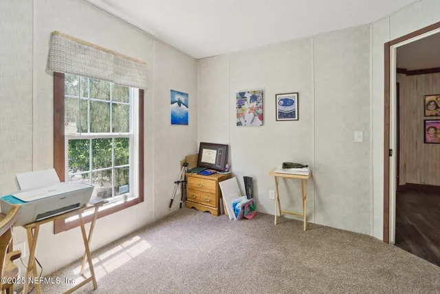 a view of a workspace with furniture and a window