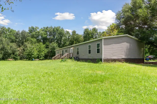 a backyard of a house with plants and large trees