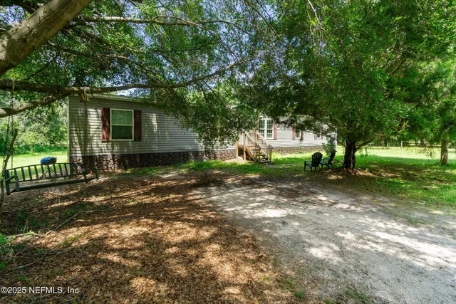 a view of a house with a tree in front of it