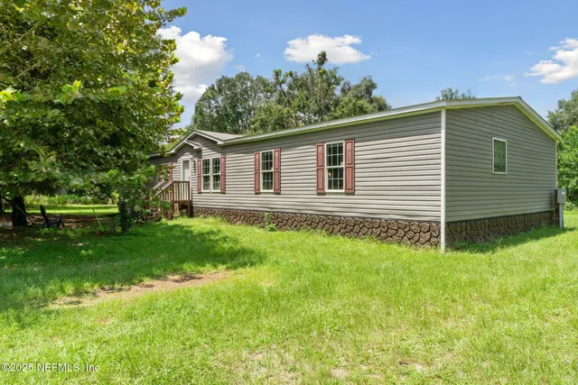 a view of a house with a backyard